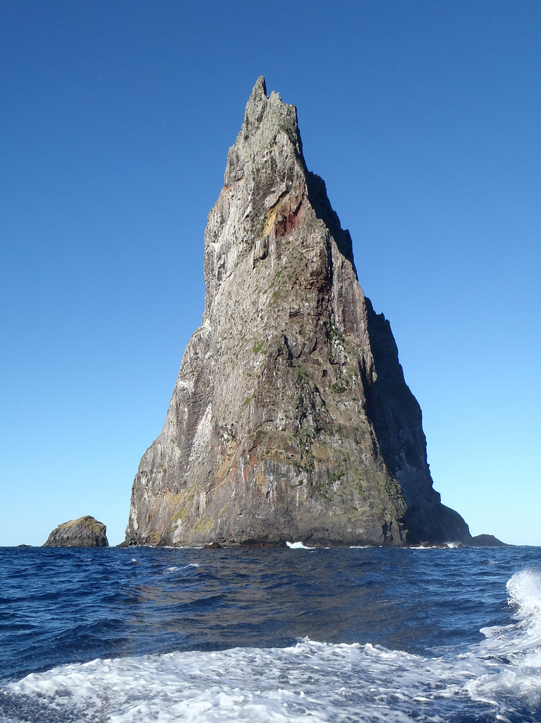 A pointed pyramid shaped rock island surrounded by sea