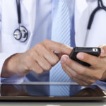 Doctor using smart phone and tablet computer.