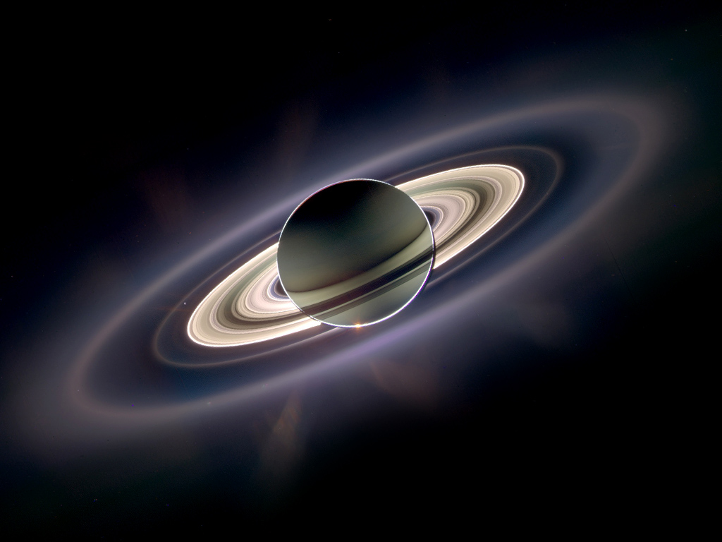 A previous observation of Saturn taken by the Cassini spacecraft. Earth can be seen as a small point of light between the rings on the left. Image: NASA/JPL/Ciclops