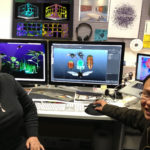 Eleanor and Chuong with printed artworks and electronic artworks featuring bugs behind them