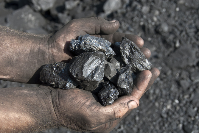 Man holding coal in hand