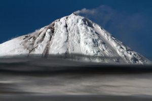 Large ice covered volcano with steam coming out the top and lava flowing down the left side