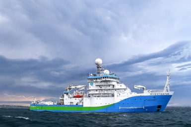 Ship with Green and blue markings in ocean with lightening bolt in background