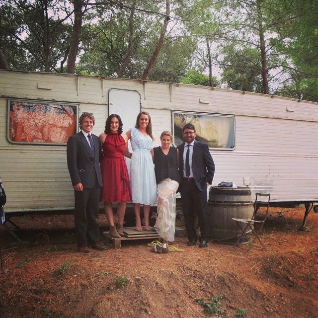 Jessie with group of people in front of old caravan.