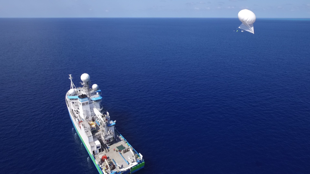A balloon-kite soars above RV Investigator to gather atmospheric data.