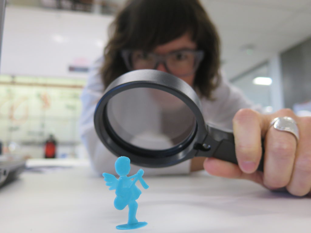 Dr Lucy looking at Polly (who is a plastic toy) through a magnifying glass