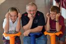 STEM volunteer working with primary school students with audio equipment