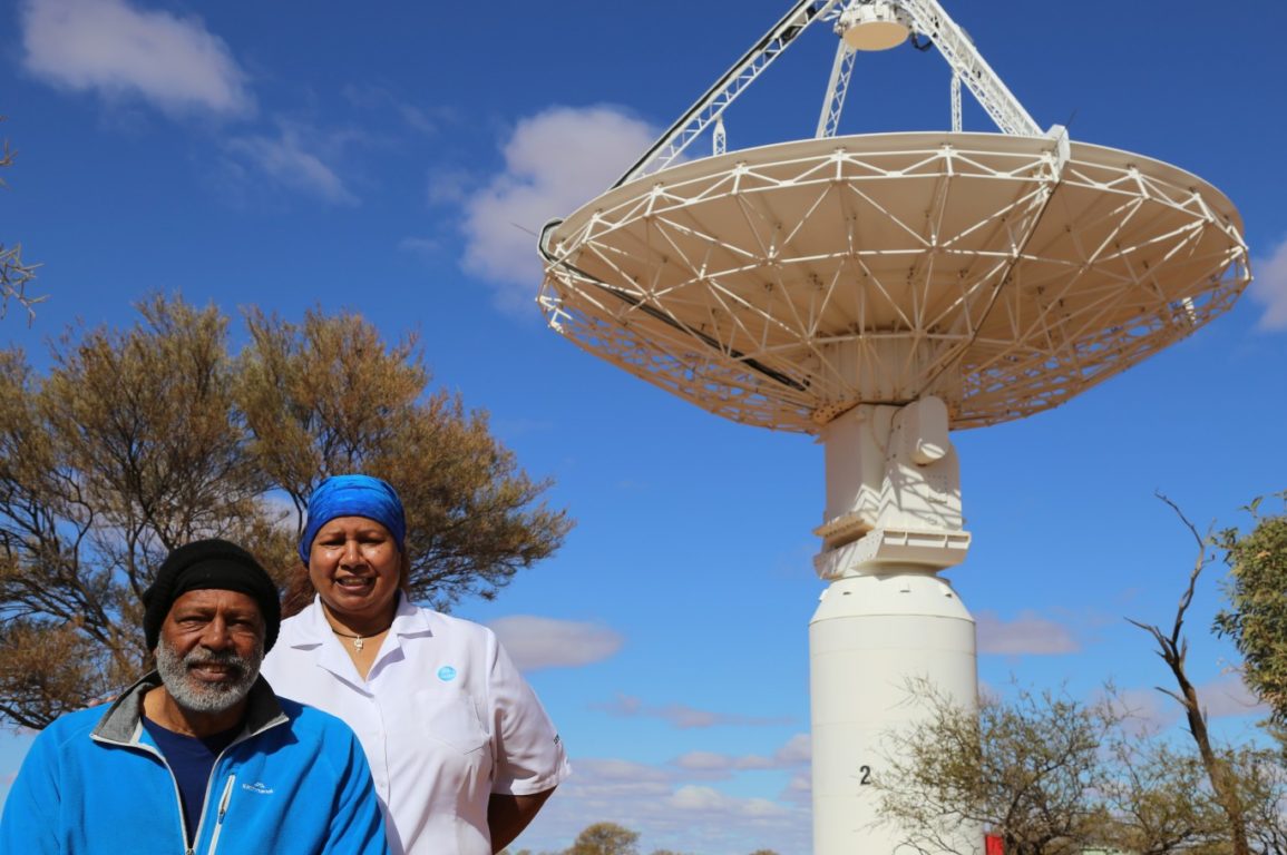 Mr Ernie Dingo and Ms Leonie Boddington, our Aboriginal Liaison Officer, under one of the ASKAP antennas at the Murchison Radio-astronomy Observatory.