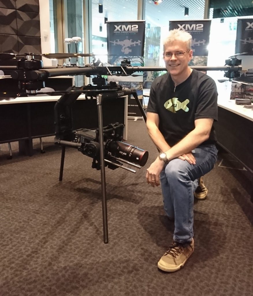 Adam Hooper standing next to a XM2 drone. 
