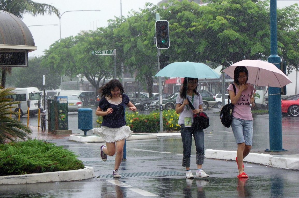 people crossing the road as it rains