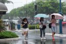 people crossing the road as it rains