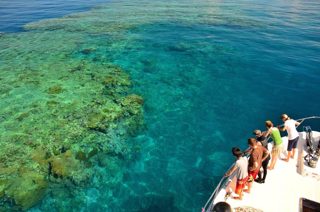 Tourists looking at the Great Barrier Reef from a boat