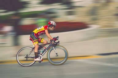 A professional cyclist riding up a hill at speed