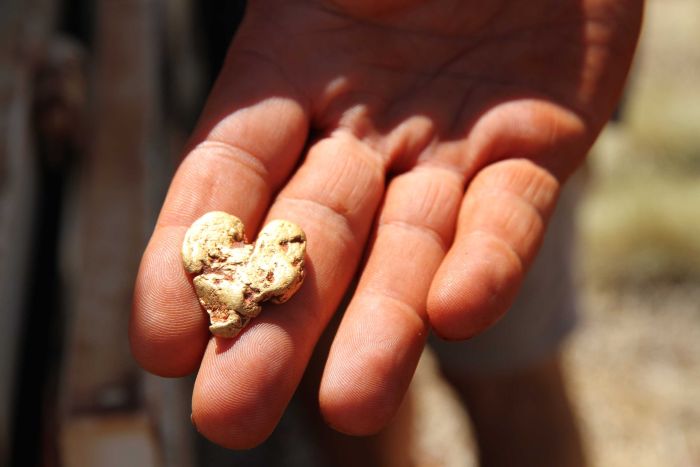 Heart-shaped gold nugget in a hand