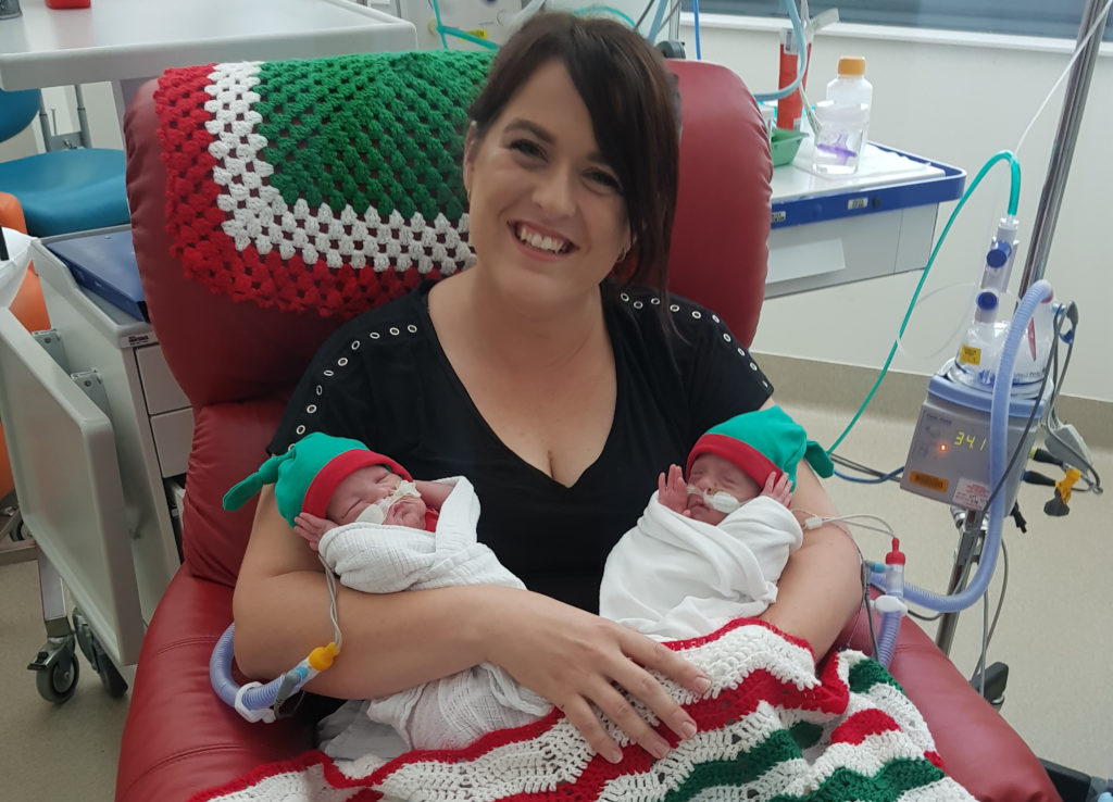 Lady holding her two premature twin babies