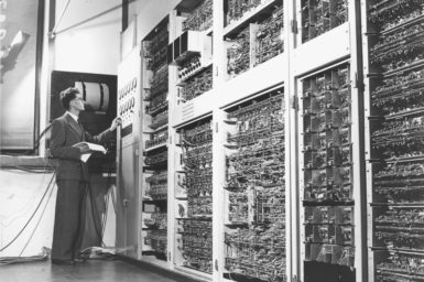 An old black and white image of scientist working with Australia’s first computer, CSIRAC.