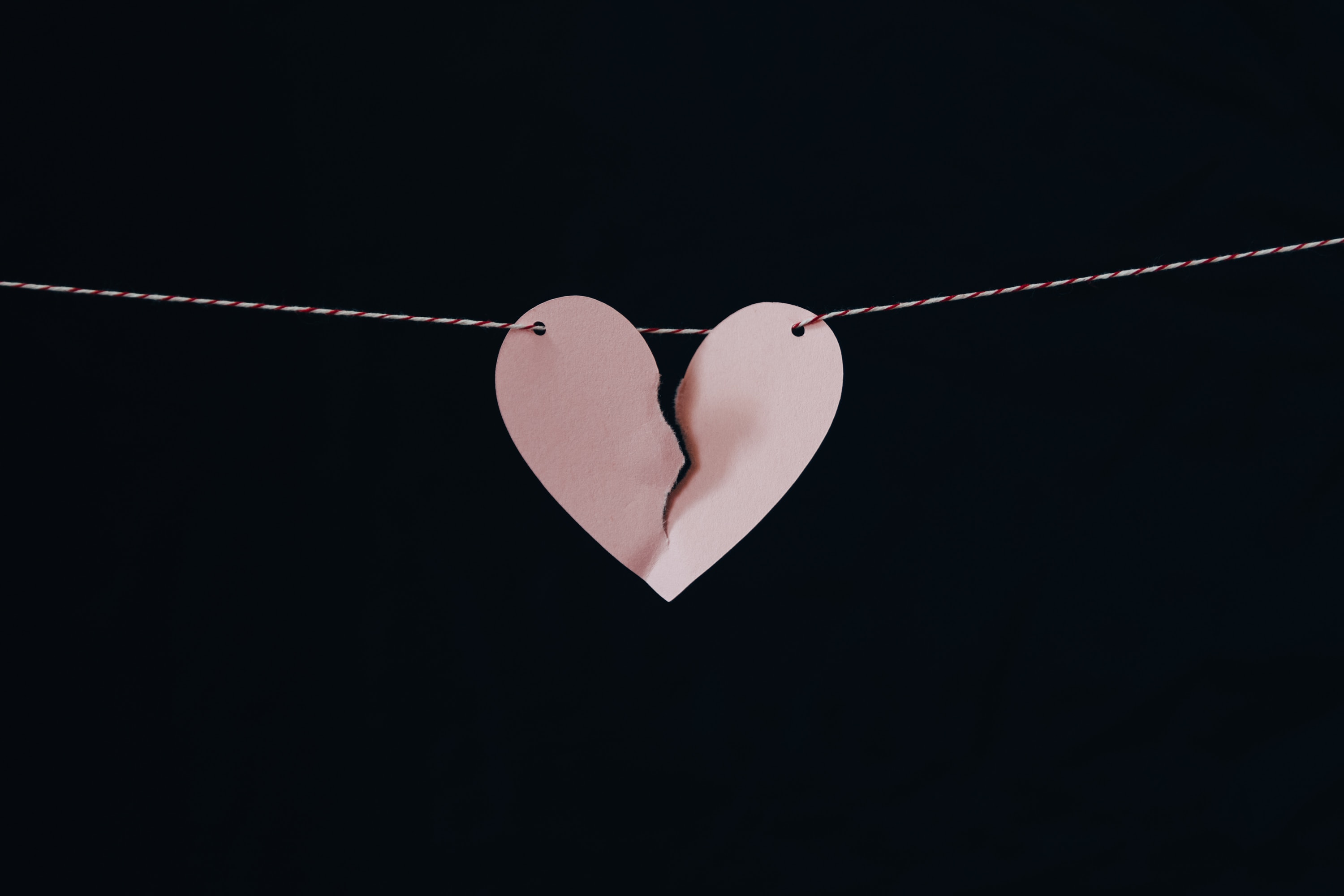 pink paper broken heart hanging on wire
