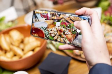 Person taking a photo of food using their phone