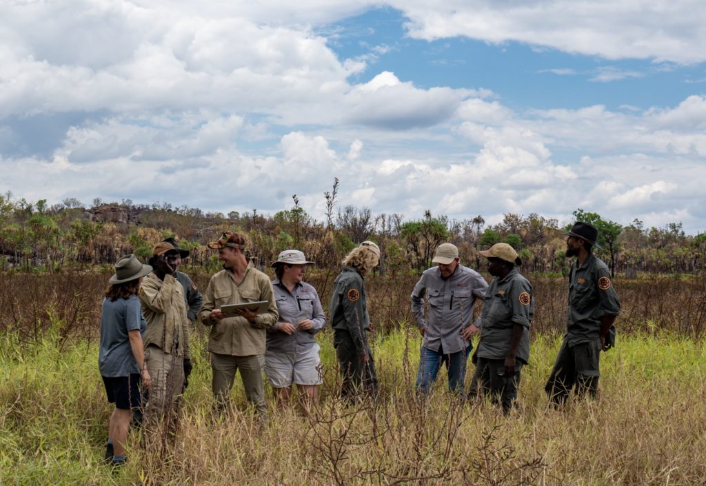 Eight people stand outside in a wetland in Kakadu.