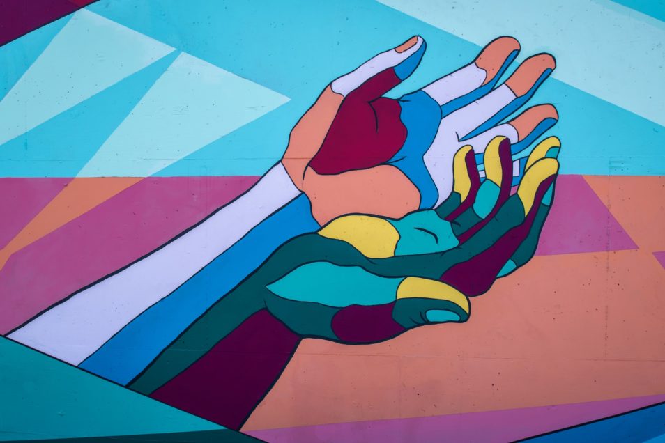 Artwork of coloured hands reaching out. A show of resilience in tough times, even while self-isolating.