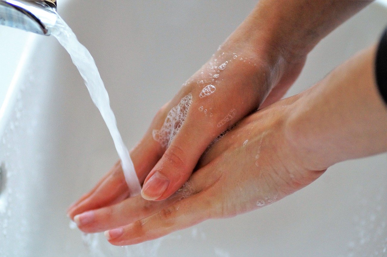 hands under a running tap washing with soap