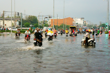Residents in Ho Chi Minh City travelling through the streets on motorbikes on a day of flooding in the city.