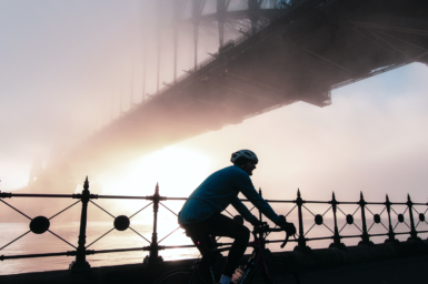 Man riding bike under the Sydney Harbour Bridge