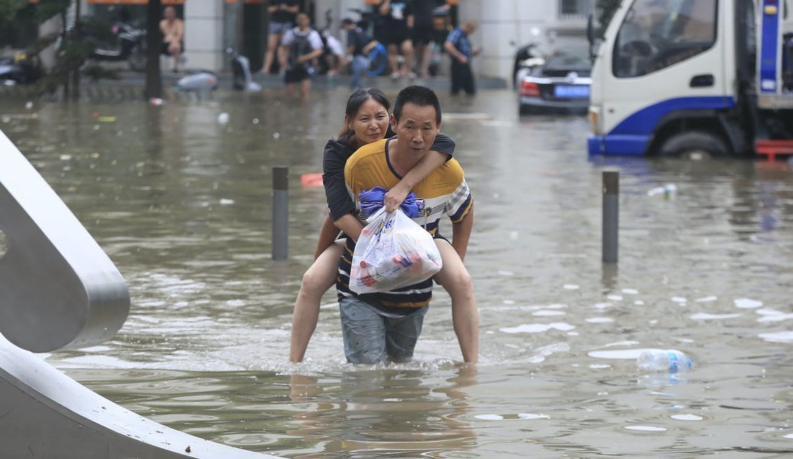 Image of people wading through a flood in a city.