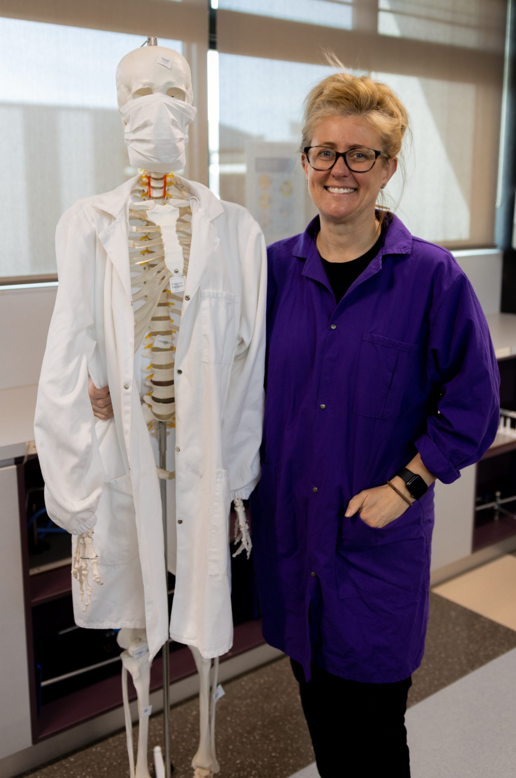 STEM teacher Kylee Townsend in the classroom with a model skeleton.
