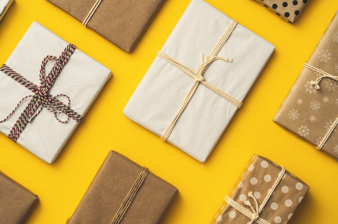 book gifts wrapped in brown paper with string on a yellow background