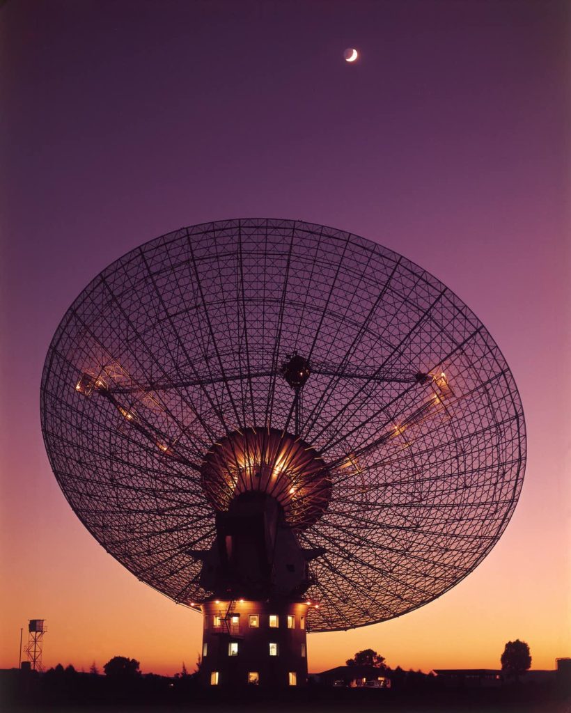 A photo of the Parkes telescope with the sunset in the background.