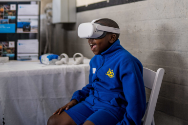 A student sits wearing a virtual reality headset