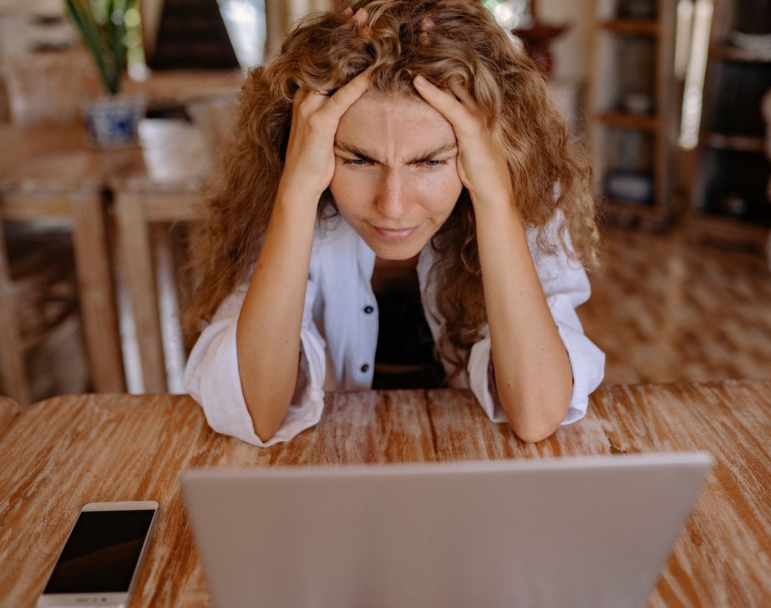 holiday season stress. Woman looks stressed and stares at computer.