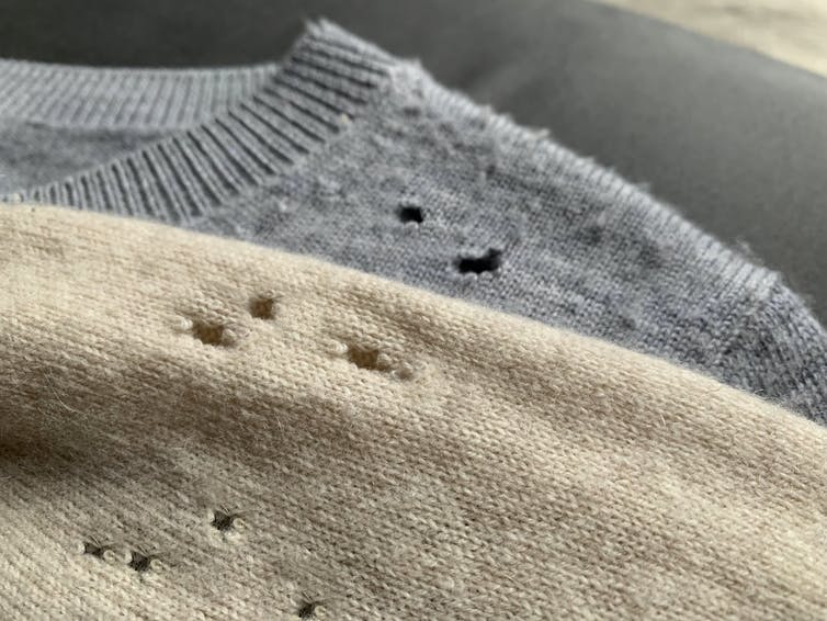 Beige and grey sweaters with holes in them.