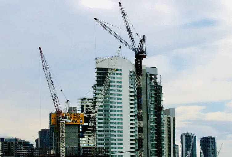 Cranes in front of a number of tall buildings