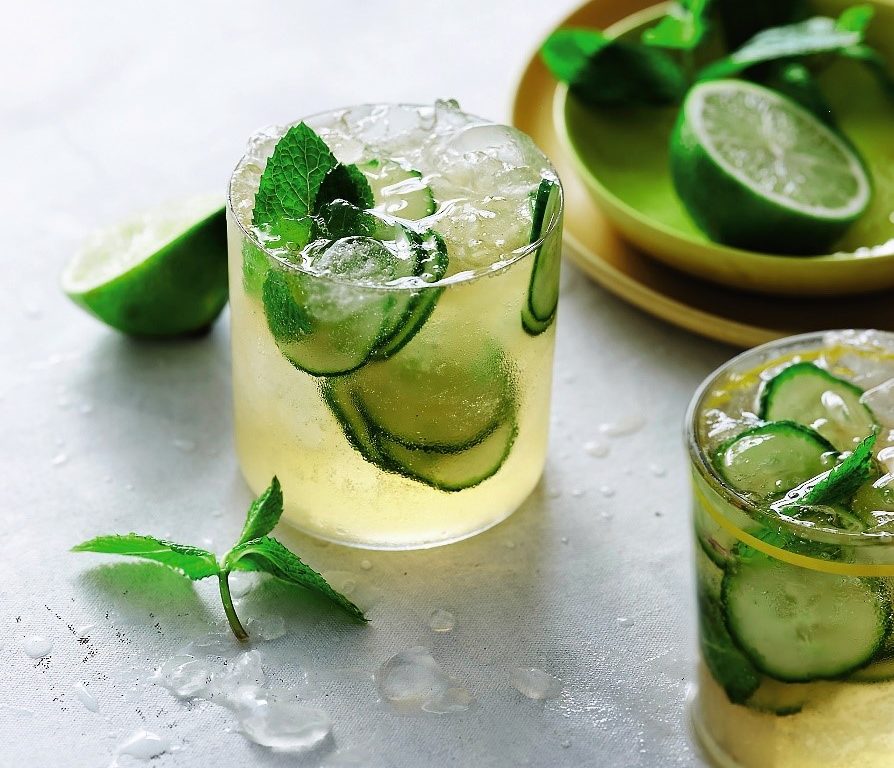 Two glasses of Mojito Kombucha Mocktail topped with cucumber and lime