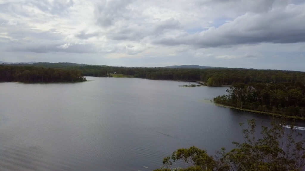 Drone image of a lake (Lake Kurwongbah) surrounded by trees.