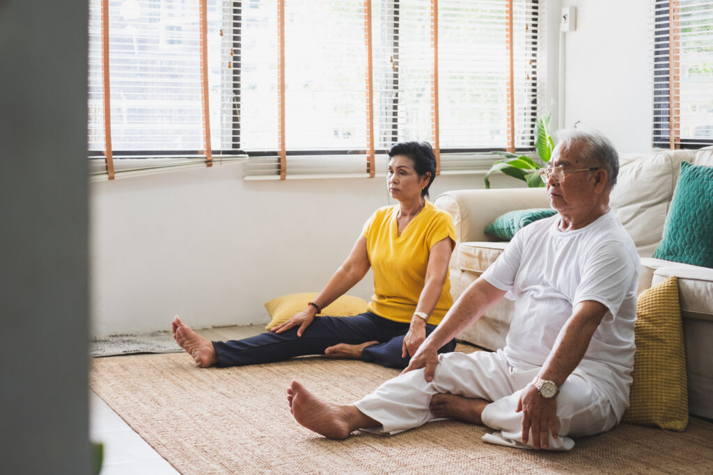 Older couple doing yoga at home