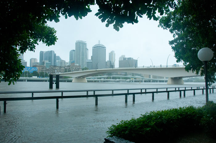 A city skyline on a rainy day with a river flooding